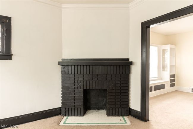 Room details featuring a fireplace, ornamental molding, and carpet flooring | Image 6