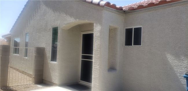 View of exterior entry featuring a tile roof and stucco siding | Image 5