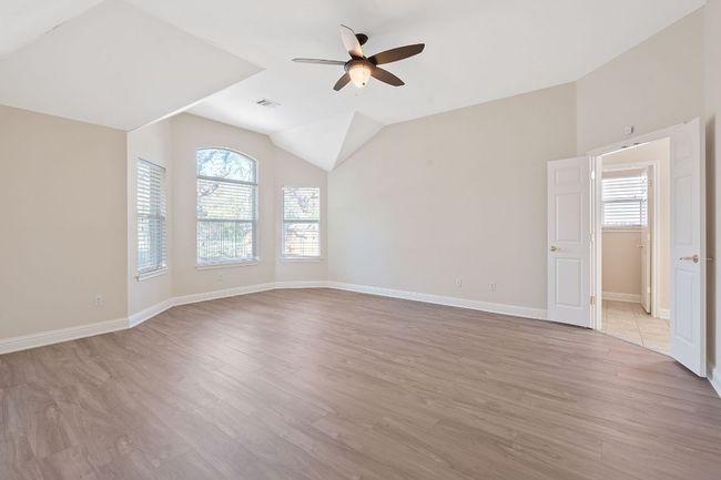 Spare room with light wood-style flooring, vaulted ceiling, and ceiling fan | Image 19