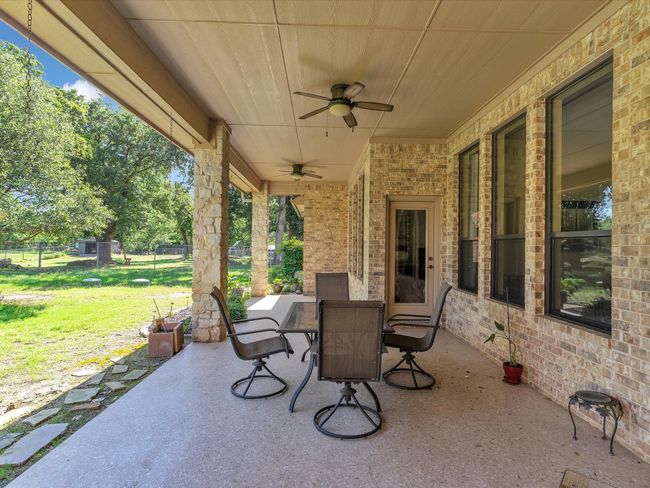 View of patio featuring outdoor dining area and ceiling fan | Image 32