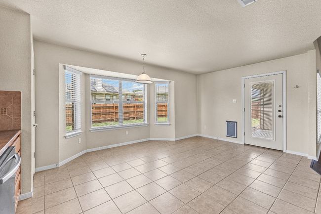 Unfurnished dining area with light tile patterned floors and a textured ceiling | Image 23