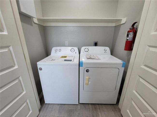 Washroom with light wood-style floors, independent washer and dryer, and laundry area | Image 17