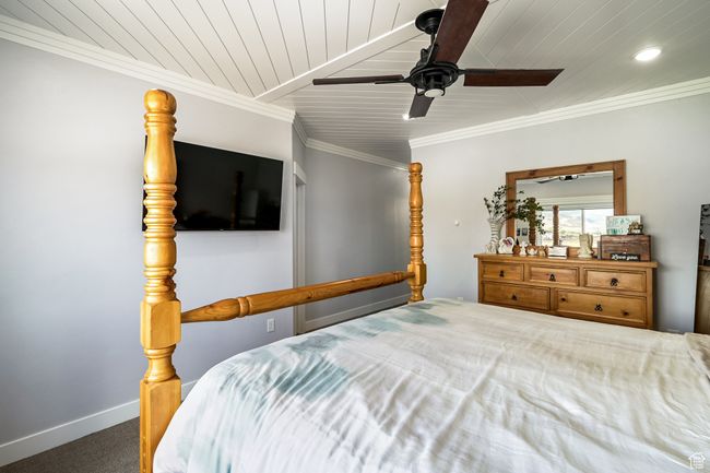 Carpeted bedroom featuring wood ceiling, a ceiling fan, recessed lighting, and crown molding | Image 39