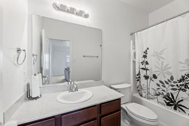 Bathroom featuring toilet, shower / bath combo with shower | Image 35