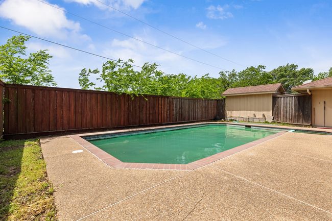 View of swimming pool featuring a fenced backyard, a fenced in pool, and a patio | Image 36