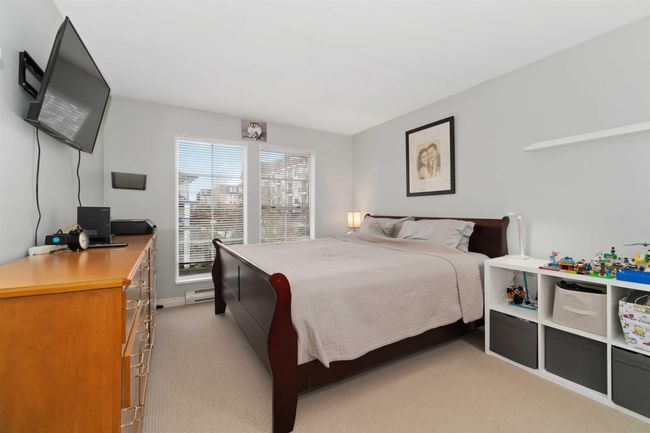 Bedroom featuring light colored carpet and a baseboard radiator | Image 18