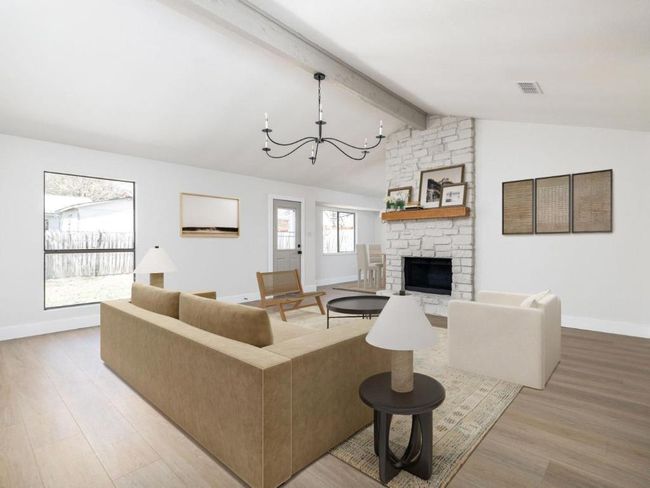 Living area featuring visible vents, baseboards, a chandelier, light wood-type flooring, and lofted ceiling with beams | Image 10
