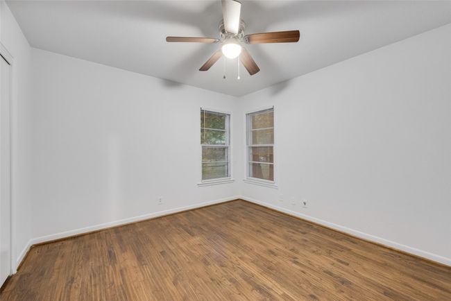 Spare room with wood finished floors, baseboards, and ceiling fan | Image 11
