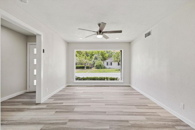 Spare room with baseboards, visible vents, wood finished floors, and ceiling fan | Image 8
