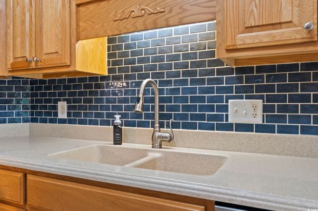 Kitchen with light countertops and tasteful backsplash | Image 12
