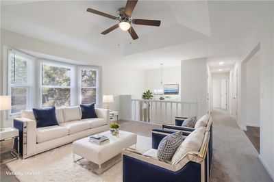 Living room featuring ceiling fan, a tray ceiling, and light hardwood / wood-style floors | Image 3