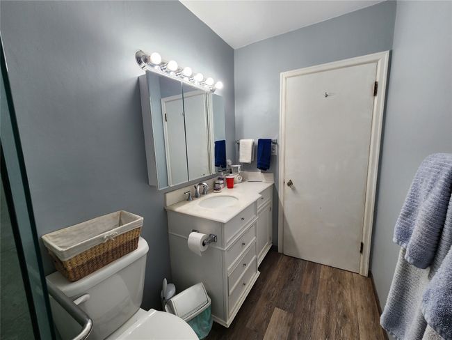 Half bathroom featuring wood finished floors, toilet, and vanity | Image 27