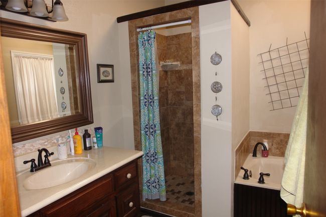 Bathroom with vanity and shower with separate bathtub | Image 9