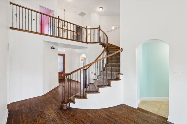 Stairway with hardwood / wood-style floors and a towering ceiling | Image 12