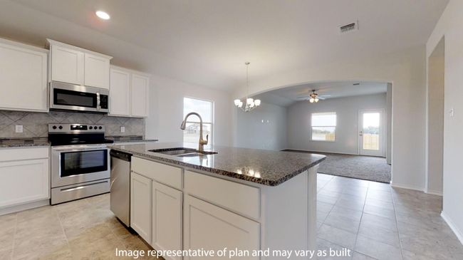 Kitchen featuring appliances with stainless steel finishes, a sink, a ceiling fan, dark stone countertops, and vaulted ceiling | Image 5