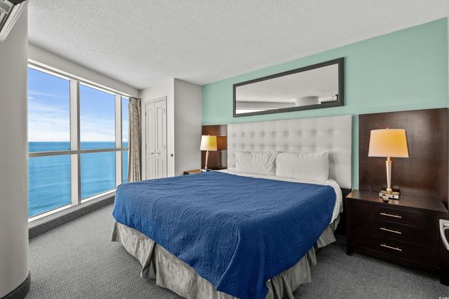 Bedroom with a water view, carpet, and a textured ceiling | Image 17