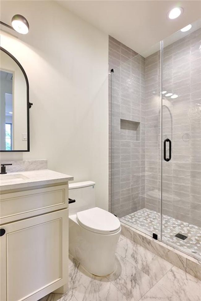Offering a sleek walk-in shower adorned with elegant Maiolica Tender Grey wall tile and a luxurious marble mosaic floor. | Image 37