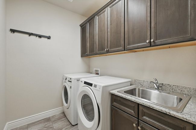 Laundry room featuring cabinet space, washer and clothes dryer, sink | Image 24