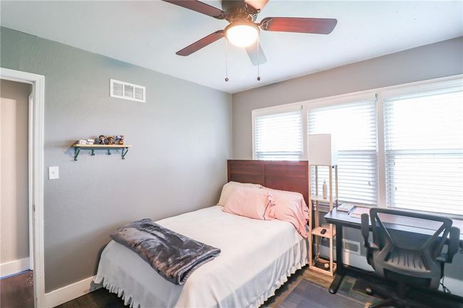 Bedroom featuring a ceiling fan and an office area | Image 32