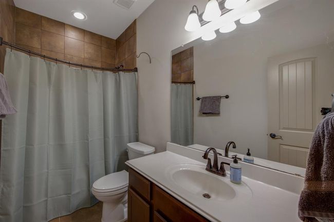 Secondary bath room sits between bedrooms 2 & 3. With a tub/shower combination, tiled to the ceiling | Image 8