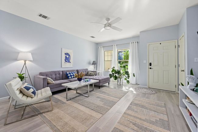 Living area with light wood-style flooring, visible vents, and ceiling fan | Image 13