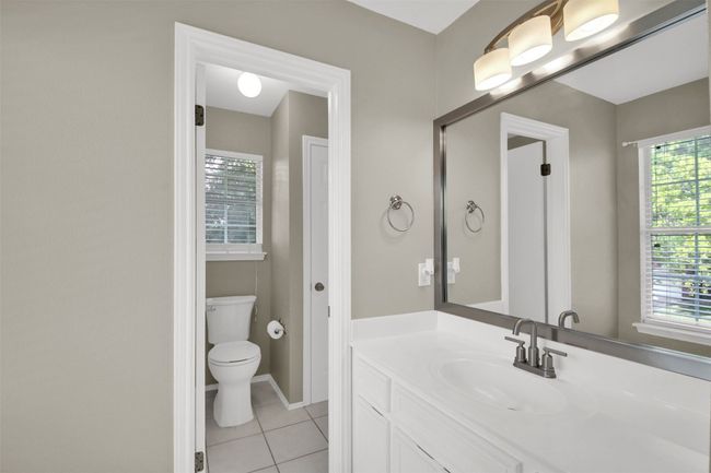 Jack and Jill bathroom with vanity, tile patterned floors, toilet, and healthy amount of natural light | Image 19