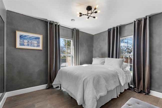 Bedroom with multiple windows, dark wood-type flooring, and a chandelier | Image 34