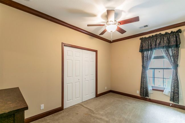 Unfurnished bedroom featuring visible vents, baseboards, a closet, ornamental molding, and carpet flooring | Image 16