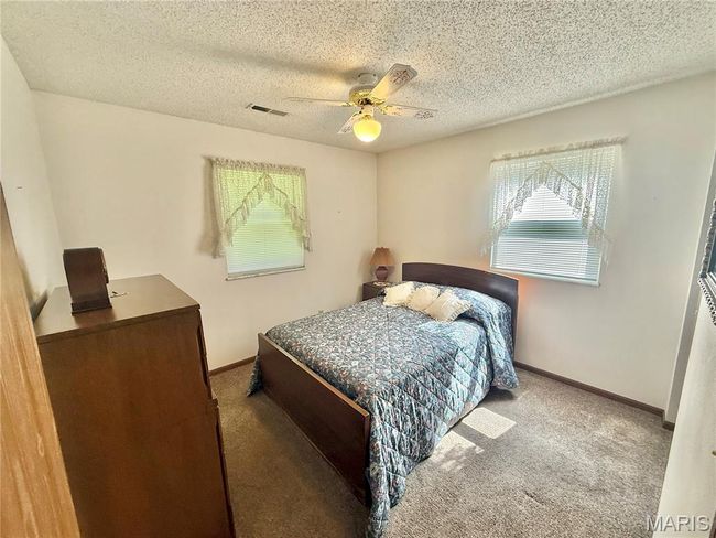 Carpeted bedroom with a textured ceiling and ceiling fan | Image 28