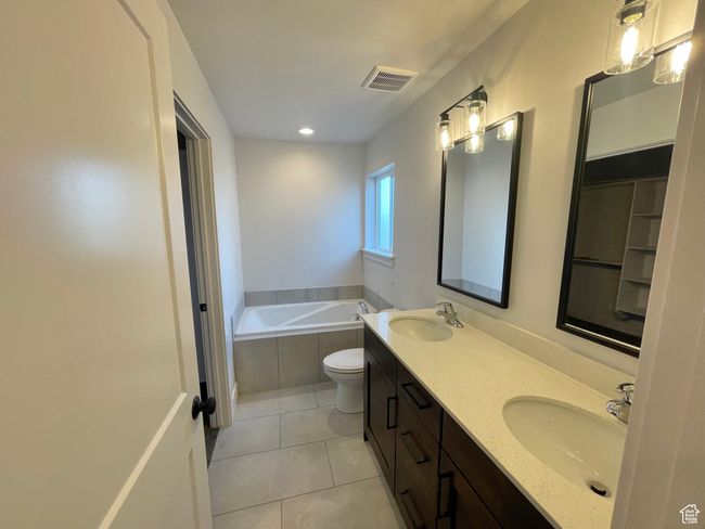 Bathroom with a bath, tile patterned flooring, a sink, and visible vents | Image 15