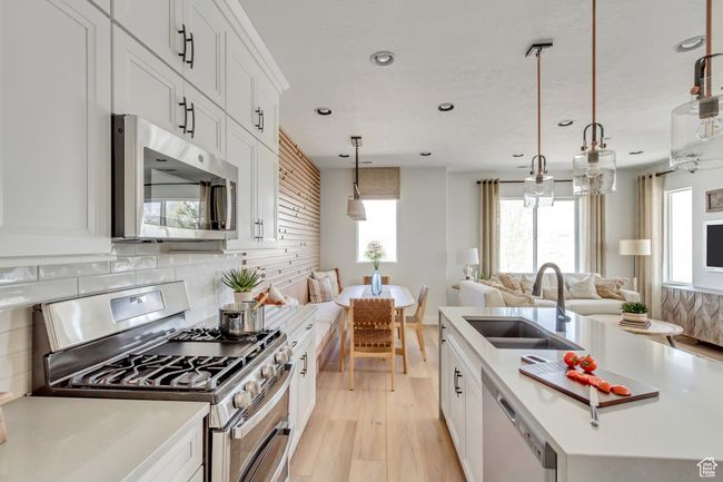 Kitchen with appliances with stainless steel finishes, recessed lighting, open floor plan, tasteful backsplash, and light wood-style floors | Image 33