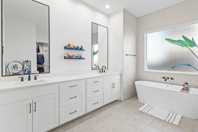 Bathroom featuring double vanity, a freestanding tub, and tile patterned floors | Image 21