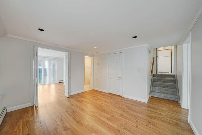 Unfurnished room featuring light wood-type flooring, ornamental molding, and a baseboard radiator | Image 24