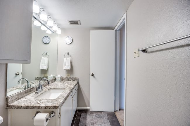 Bathroom featuring vanity, a textured wall, a textured ceiling, and baseboards | Image 16