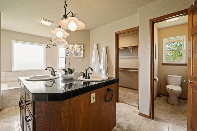 The primary bath has both his and her baths with a water closet | Image 13