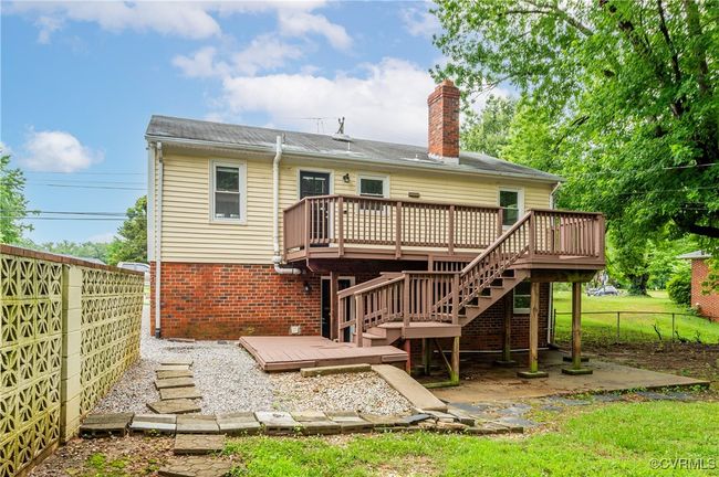 Back of house with a deck, a fenced backyard, a chimney, and brick siding | Image 28