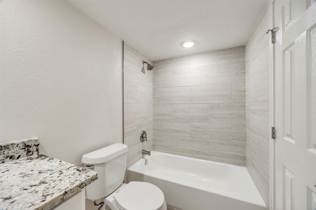 Full bathroom featuring tiled shower / bath combo, toilet, and vanity | Image 18