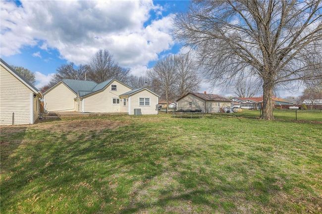 View of yard featuring a trampoline, central AC, and fence | Image 6