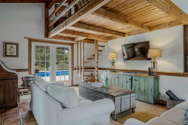 Living area with wooden ceiling with exposed beams and french doors | Image 9