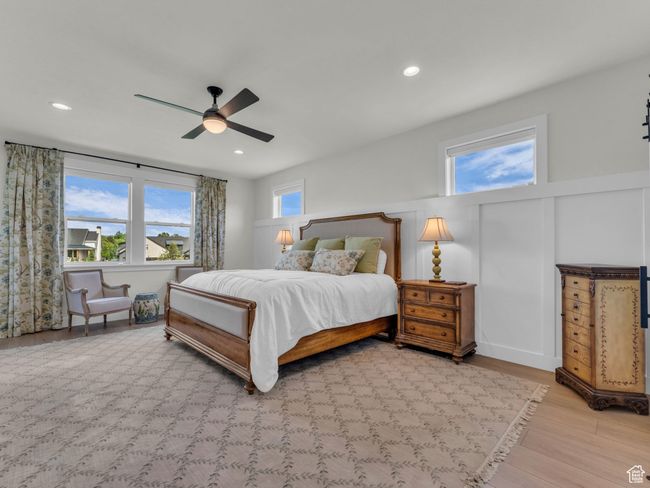 Bedroom featuring wood finished floors, a ceiling fan, recessed lighting, and wainscoting | Image 21
