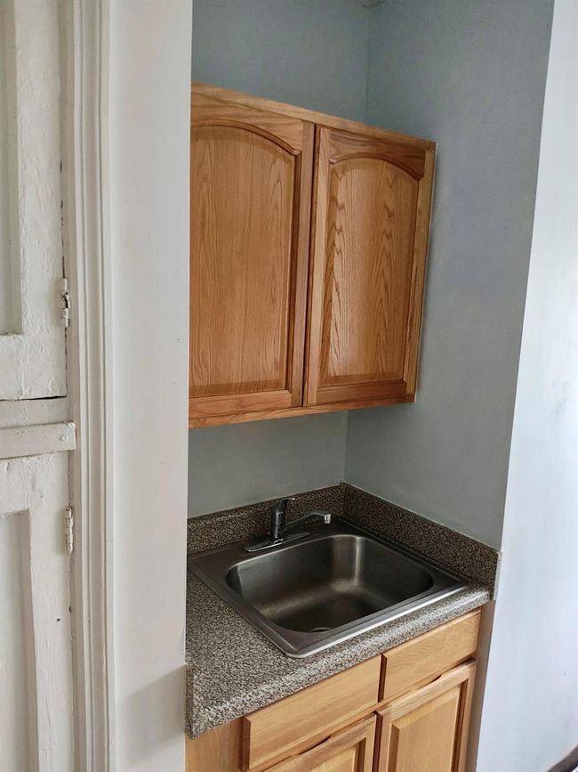 Kitchen featuring dark countertops and a sink | Image 9