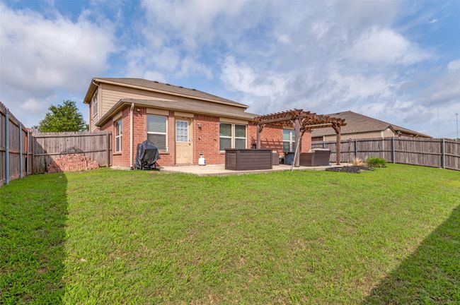 Back of property featuring a fenced-in and nicely-sized backyard. | Image 36