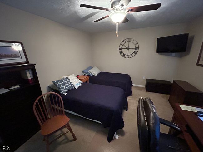 carpeted bedroom with a textured ceiling, baseboards, and ceiling fan | Image 9