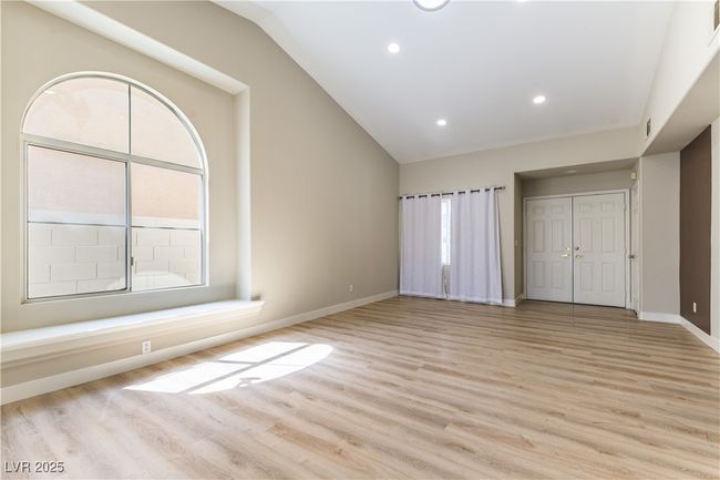 Unfurnished bedroom with lofted ceiling, light wood-style floors, baseboards, recessed lighting, and a closet | Image 4