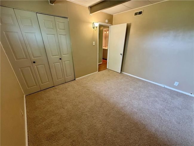 Unfurnished bedroom featuring visible vents, a closet, beam ceiling, baseboards, and carpet floors | Image 12