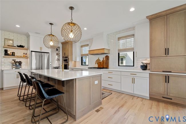 Kitchen featuring backsplash, light countertops, a kitchen breakfast bar, open shelves, and recessed lighting | Image 4