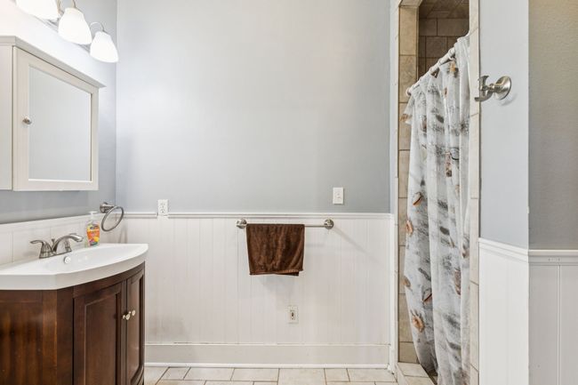Bathroom featuring a wainscoted wall, vanity, and a shower with shower curtain | Image 19