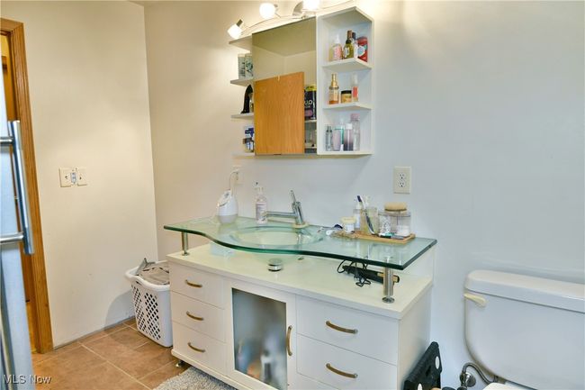 Bathroom with toilet, tile patterned flooring, and vanity | Image 27