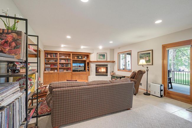 Fireplace and bookshelf add warmth and functionality. | Image 31