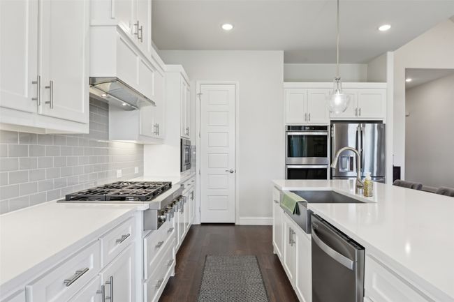 Kitchen with appliances with stainless steel finishes, light countertops, pendant lighting, white cabinets, and recessed lighting | Image 15